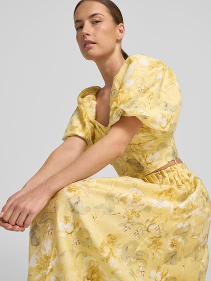 Frauenmodel trägt Cropped Blusentop mit Puffärmeln Modell 'LEMON' von YAS, Lyocell-Mix mit Leinen-Anteil, Allover-Look, Knotendetail, Nahaufnahme Oberkörper.