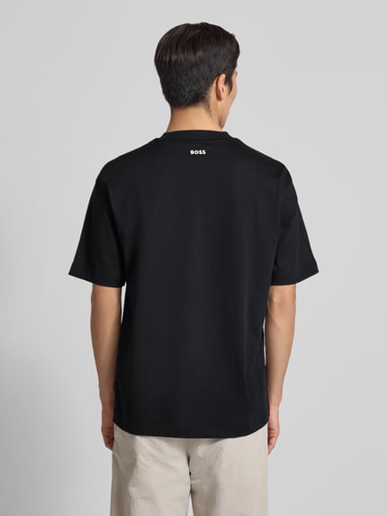 Männermodel trägt Regular Fit T-Shirt aus Baumwoll-Mix Modell 'TEETIM' von BOSS Orange, Optik: Unifarben, Label-Print, Ganzkörperansicht Rückansicht.