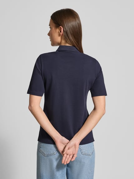 Frauenmodel trägt Poloshirt aus Baumwolle mit Label-Detail von GANT in Dunkelblau, gerader Schnitt, Polokragen, 1/2-Arm, Rückenlänge 59 cm, Ganzkörperansicht Rückansicht.