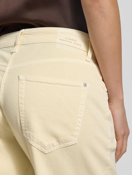 Frauenmodel trägt Straight Fit Jeans mit Eingrifftaschen Modell 'Elin' von Cambio aus elastischem Baumwoll-Mix in Creme mit Gesäßtaschen, Detailaufnahme Rückansicht.