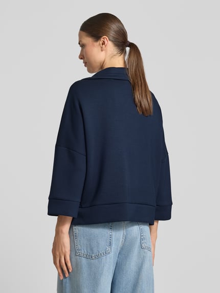 Frauenmodel trägt Boxy Fit Sweatjacke mit Viskose-Anteil von Tom Tailor in Dunkelblau, strukturierte Oberfläche, Ganzkörperansicht Rückansicht, Damen Sweatjacke von Tom Tailor.