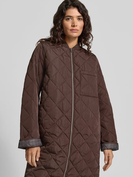Frauenmodel trägt Slim Fit Steppmantel mit aufgesetzter Eingrifftasche von Jake*s Casual, unifarben, gesteppte Textur, Nahaufnahme Oberkörper.