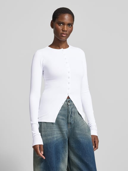 Frauenmodel trägt Longsleeve mit durchgehender Knopfleiste von black palms, weiß, unifarben, Rundhals, Rippstruktur, geschlitzter Saum, Ganzkörperansicht von vorne.