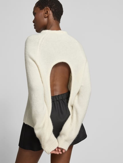Frauenmodel trägt Regular Fit Pullover aus Alpaka-Mix von black palms in Strick-Optik mit Rundhalsausschnitt, Rückenlänge 60 cm, Ganzkörperansicht Rückansicht.