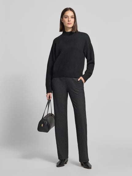Frauenmodel trägt Regular Fit Weite Hose mit Bügelfalten von BRAX in Dunkelgrau, Strukturmuster, High Waist, 7/8-Länge, Ganzkörperansicht von vorne.