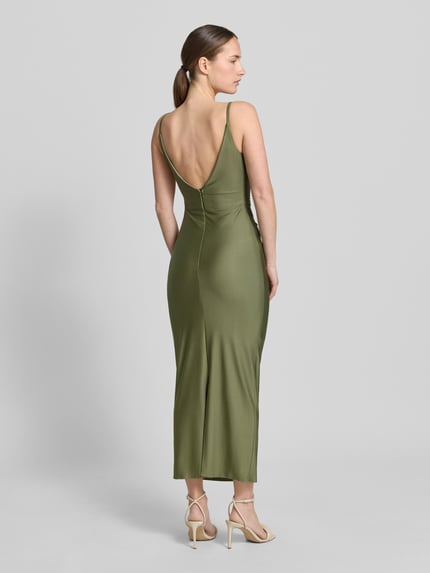 Frauenmodel trägt Cocktailkleid mit Spaghettiträgern und V-Ausschnitt von TROYDEN COLLECTION aus grünem Satin, Körpernaher-Schnitt, Midikleid mit Rückseitigem V-Ausschnitt und Rückenreißverschluss, glatte Oberfläche, Ganzkörperansicht Rückansicht.