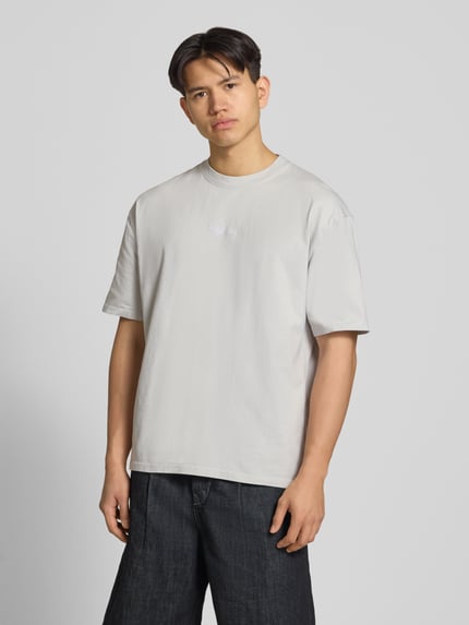 Männermodel trägt Oversized T-Shirt mit 1/2-Arm Modell 'Towson' von Pegador, hellgraue Baumwolle, Rundhalsausschnitt, Ganzkörperansicht von vorne.