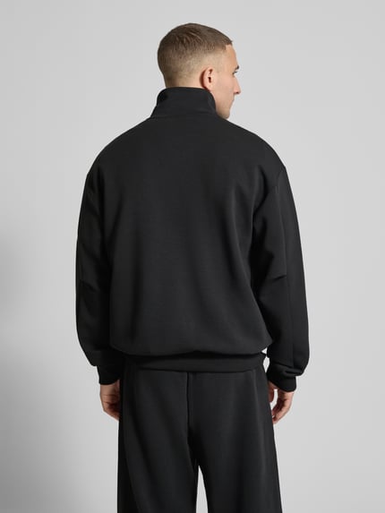 Männermodel trägt Loose Fit Sweatjacke mit Modal und Baumwoll-Anteil von adidas Sportswear, Optik: Unifarben, Ganzkörperansicht Rückansicht.