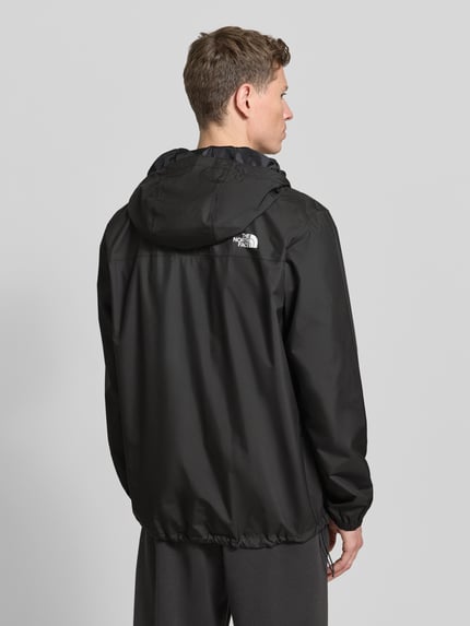 Männermodel trägt Regular Fit Jacke mit Logo-Print Modell 'Quest' von The North Face, schwarze Farbe, glatte Textur, Ganzkörperansicht Rückansicht. Damen Jacke, Kapuze, Reißverschluss, Rückenlänge 100 cm, Schulterbreite 46 cm, Brustweite 58 cm, Ärmellänge 68 cm.