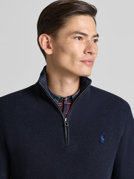 Männermodel trägt Strickpullover mit Label-Stitching von Polo Ralph Lauren, reine Baumwolle, dunkelblau, Nahaufnahme Oberkörper.