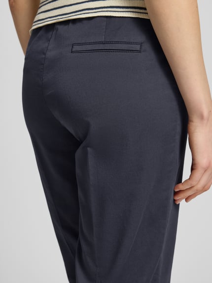 Vrouwenmodel draagt Wide Fit stoffen broek in 7/8-lengte model 'Sue' van TONI in katoenmix met persplooien, steekzakken, detailopname rugaanzicht.
