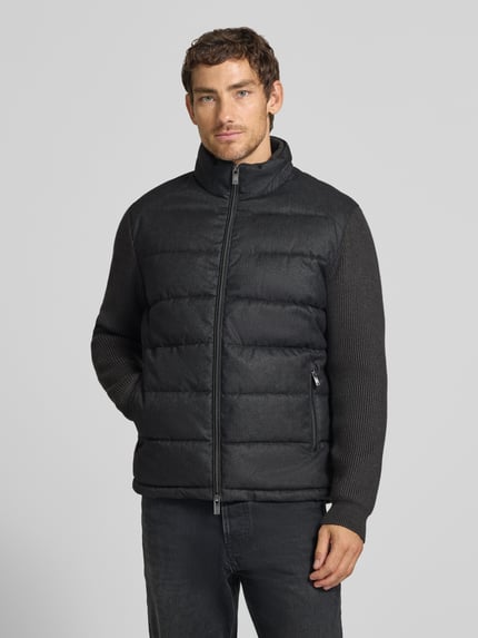 Männermodel trägt Steppjacke mit Stehkragen und Zweiwege-Reißverschluss von Christian Berg Men in Dunkelgrau, Ganzkörperansicht von vorne. Context: Herren Steppjacke Regular Fit, Reißverschlusstaschen, Rückenlänge 70 cm, Schulterbreite 51 cm, Brustweite 60 cm, Ärmellänge 69 cm.