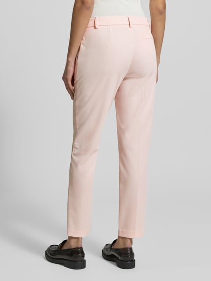 Vrouwenmodel draagt Hose mit Bügelfalten van Christian Berg Woman Selection in lichtroze materiaalmix met viscose, regular fit, persplooien, achterzak, bandwijdte maat 36: 42 cm, binnenbeenlengte maat 36: 72 cm. Ganzlichaamsaanzicht achteraan.