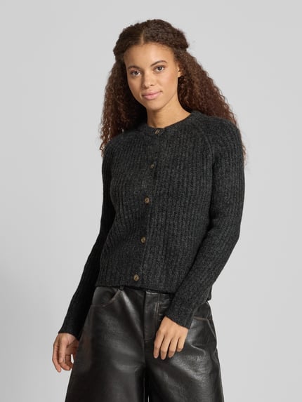 Kobiece model prezentuje Regular Fit kardigan rozpinany z dodatkiem wełny model 'ASHLEY CARDIGAN' od Pepe Jeans, jednokolorowy, imitacja dzianiny, fakturowany wzór, krój regular fit, krótki krój, ozdobne guziki, długi rękaw, raglanowe rękawy, okrągły dekolt, listwa guzikowa na całej długości, prążkowane zakończenie rękawów i dołu, wykończenie: dzianina, drobny splot, prążkowana dzianina, widok z przodu, ujęcie do połowy sylwetki.