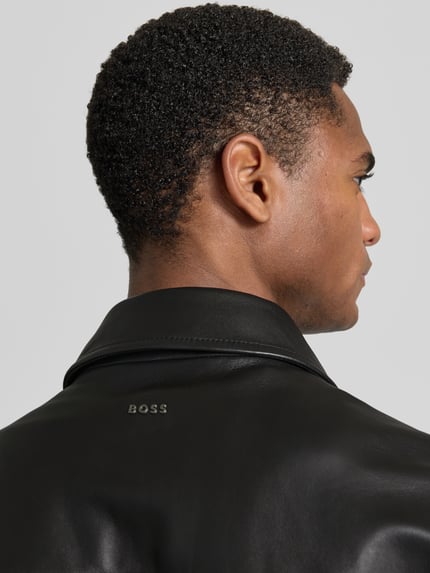 Männermodel trägt Regular Fit Lederjacke Modell 'JOBAN' von BOSS Orange in schwarzer Lederoptik, Material Echtleder, Nahaufnahme Rücken.