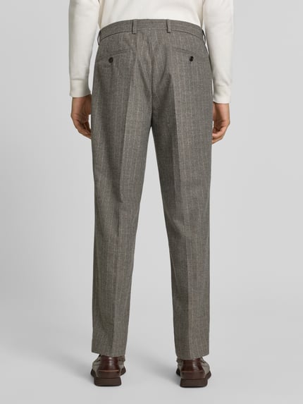 Mężczyzna nosi Regular Fit Weite Hose aus Woll-Mix mit Viskose-Anteil od JOOP! COLLECTION, szare spodnie w prążki, tekstura wełny, widok całej sylwetki z tyłu.