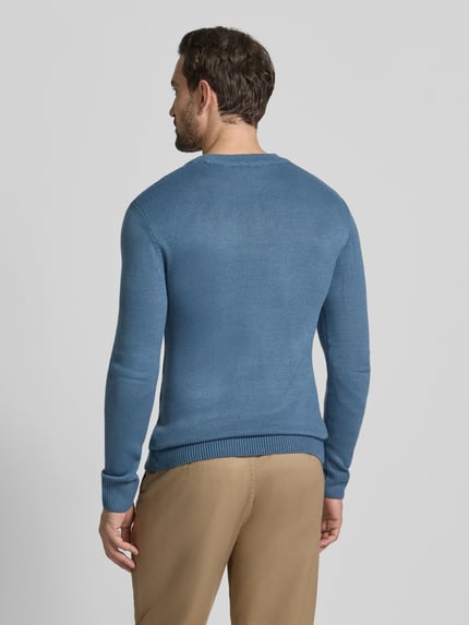 Männermodel trägt Regular Fit Strickpullover aus Rippstrick von Tom Tailor Denim in Blau, gerippte Abschlüsse, unifarben, Ganzkörperansicht Rückansicht.