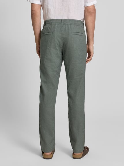 Männermodel trägt Regular Fit Leinenhose aus Leinen-Mix Modell 'Sanderson-L-3' von BOSS in Grün mit Label Patch, Rückansicht.