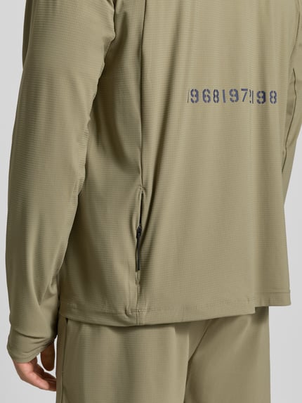 Mężczyzna nosi Funktionsshirt mit Stehkragen und Reißverschluss Modell 'AIR' od HALO, z materiału z domieszką stretchu, krój regular fit, z nadrukiem z tyłu, struktura o drobnej fakturze, kolor oliwkowy, zdjęcie w zbliżeniu na plecy