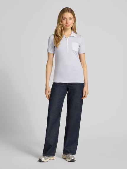 Frauenmodel trägt Regular Fit Poloshirt aus reiner Baumwolle von Marc O'Polo, Optik: Unifarben, Logo-Print, Polokragen, Brusttasche, Materialverarbeitung: Jersey, Ganzkörperansicht von vorne.