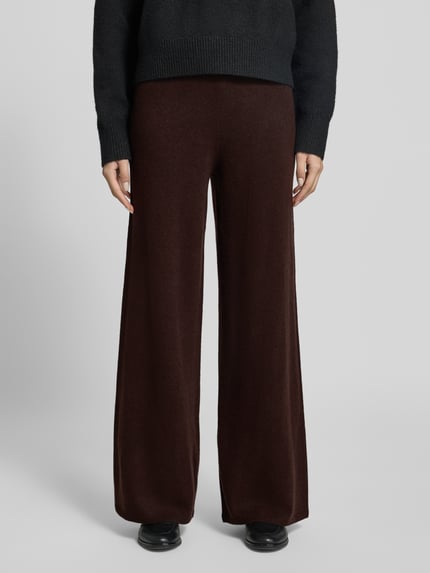 Männermodel trägt Wide Leg Wollhose aus reiner Wolle von Stefanel, strickartige Struktur, dunkelbraune Farbe, szerokość w rozmiarze S: 34 cm, długość nogawki wewnętrznej w rozmiarze S: 83 cm, elastyczny pas, pełny widok z przodu