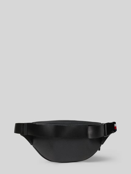 Produktfoto, Bauchtasche mit Strukturmuster von Tommy Hilfiger aus robustem Material in Schwarz, Hauptfach mit Reißverschluss, Label-Schriftzug, Logo-Details, verstellbarer Schulterriemen mit Klickverschluss, Reißverschlussfach innen, Breite 36 cm, Länge 15 cm, Tiefe 5 cm, Länge Schulterriemen 90 cm.