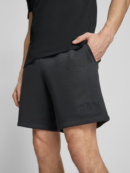 Männermodel trägt Sweatshorts mit elastischem Bund von GAP aus Baumwoll-Mix, Relaxed-Fit, Logo, Detailaufnahme Oberschenkel.