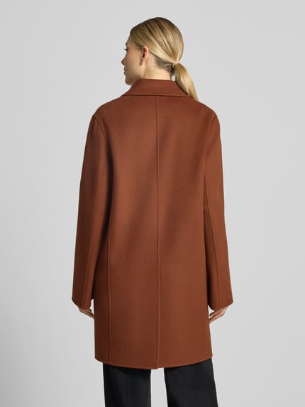 Frauenmodel trägt Mantel mit Reverskragen Modell 'RYTON' von DRYKORN in Braun, Regular Fit, glatte Textur, Ganzkörperansicht Rückansicht. Baumwoll-Mix, Knopfverschluss, Rückseite zeigt klare Linien.