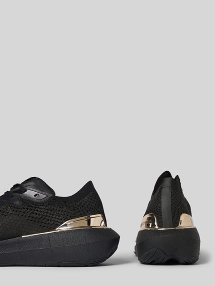 Produktfoto, Sneaker mit Label-Details Modell 'ATOMIC SPEED' von PLEIN SPORT, schwarze Textil-Oberfläche, strukturierte schwarze Sohle, goldfarbene Akzente, abgerundete Form, Schnürung, Kontext: Herren Sneaker, Absatzhöhe 5 cm, Schafthöhe 7 cm, Schaftweite 10 cm