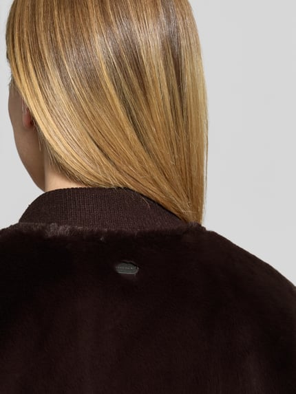 Frauenmodel trägt Regular Fit Mantel aus Kunstfell Modell 'Wender' von Beaumont Amsterdam in Dunkelbraun, Detailaufnahme Rücken, Damen Mantel, Kunstfell, Stehkragen, Zweiwege-Reißverschluss, Rückenlänge 92 cm, Schulterbreite 54 cm, Brustweite 46 cm, Ärmellänge 62 cm