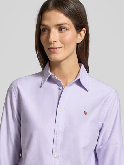 Vrouwenmodel draagt Hemdbluse mit Knopfleiste van Polo Ralph Lauren in lichtpaars, katoenen stof, losse pasvorm, detailopname bovenlichaam.