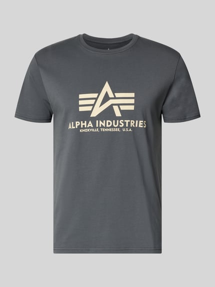 Produktfoto, T-Shirt mit Logo und Rundhalsausschnitt von Alpha Industries in Grau mit großem beigem Logo-Print, reine Baumwolle, Regular Fit.