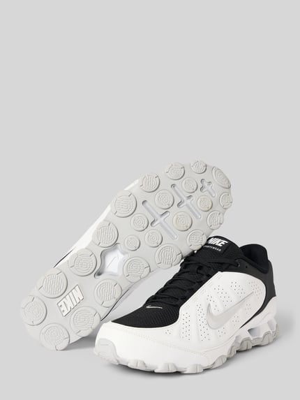Produktfoto, czarno-białe sneakersy z detalem z logo, model 'REAX 8 NSW SL' od Nike, tekstura siateczki i skóry, sneakersy męskie