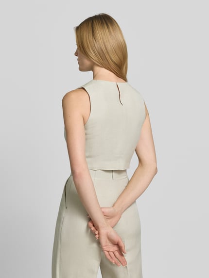 Frauenmodel trägt Cropped Bluse mit Knopfverschluss von Style Icon Collection aus reiner Baumwolle in Beige, Rückansicht, Ganzkörperansicht.