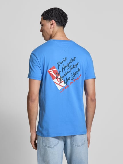 Männermodel trägt Regular Fit T-Shirt aus reiner Baumwolle von Tommy Jeans, unifarbenes Jersey mit Label Print, Ganzkörperansicht Rückansicht.