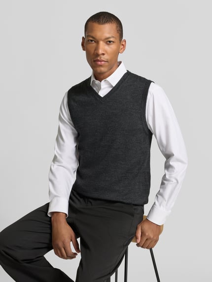 Männermodel trägt Slim Fit Pullunder aus Baumwoll-Mix mit V-Ausschnitt von Christian Berg Men, Strick-Optik, Dunkelgrau, Nahaufnahme Oberkörper.