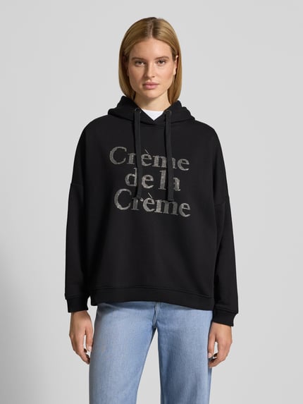 Vrouwenmodel draagt Oversized Hoodie mit Kapuze van miss goodlife in zwart, katoen, labeldetail, geribde boorden, vooraanzicht bovenlichaam