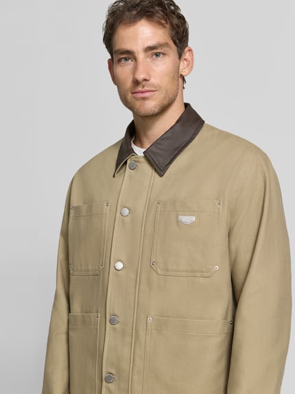 Männermodel trägt Regular Fit Jacke aus reiner Baumwolle von Antony Morato in Beige mit Umlegekragen, Knopfleiste und Taschen, Nahaufnahme Oberkörper. Rückenlänge 72 cm, Schulterbreite 61 cm, Brustweite 48 cm, Ärmellänge 68 cm.
