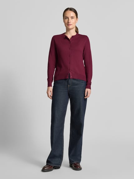 Frauenmodel trägt Regular Fit Strickjacke aus Viskose-Mix von s.Oliver RED LABEL in Dunkelrot zu blauen Jeans, Ganzkörperansicht von vorne, Damen Strickjacke von s.Oliver RED LABEL.