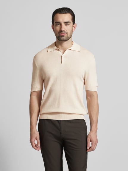 Männermodel trägt Slim Fit Poloshirt mit Kaschmir-Anteil von FTC Cashmere, Baumwoll-Mix, Polokragen, Knopfleiste, 1/2-Arm, Ganzkörperansicht von vorne.