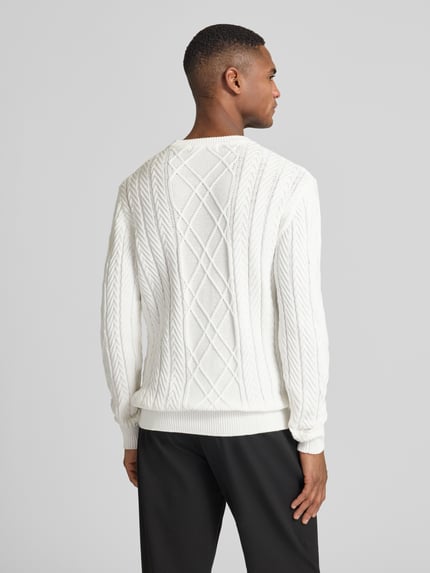 Męski model nosi Strickpullover aus Baumwoll-Modal-Mix od Guess, biały, regular fit, okrągły dekolt, widoczne żebrowanie. Cała sylwetka z tyłu.