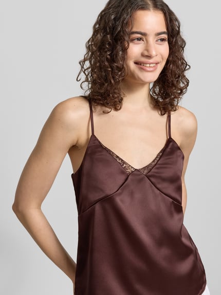 Frauenmodel trägt Regular Fit Trägertop mit Spitzenbesatz Modell 'RAYA' von Only, Optik: Unifarben, Materialverarbeitung: Satin, Nahaufnahme Oberkörper.