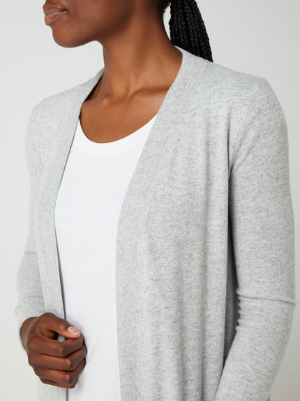 Frauenmodel trägt Longcardigan mit aufgesetzten Taschen Modell 'CITY' von Noisy May, grau, Material-Mix mit Stretch-Anteil, Nahaufnahme Oberkörper.