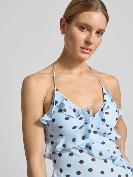 Frauenmodel trägt Maxikleid mit Volants Modell 'Kimberley' von Forever New aus hellblauem Chiffon mit braunen Punkten, Nahaufnahme Oberkörper. Rückenlänge bei Größe 36: 150 cm, Brustweite bei Größe 36: 36 cm, A-Linie.