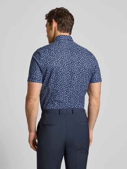 Männermodel trägt Slim Fit Freizeithemd mit floralem Allover-Print von OLYMP Level Five in Dunkelblau und Weiß, Rückenansicht, Kurzärmelig, Kentkragen, Elastischer Baumwoll-Mix, Herren, Knopfleiste, Rückenlänge 71 cm, Schulterbreite 44 cm, Ärmellänge 23 cm.
