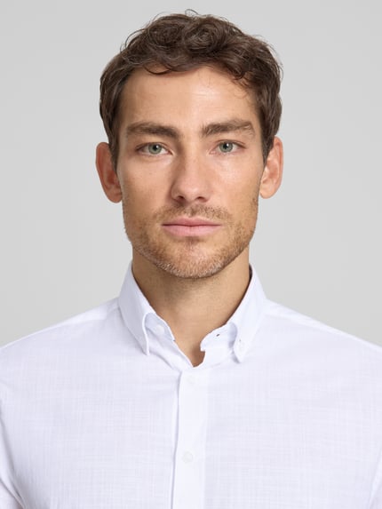 Männermodel trägt Regular Fit Freizeithemd mit Button-Down-Kragen von bugatti, Reine Baumwolle, Knopfleiste, Nahaufnahme Oberkörper.