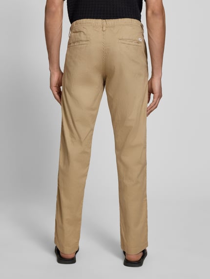 Mężczyznamodel nosi Relaxed Fit Hose aus Baumwoll-Leinen-Mix Modell 'KANE' od Jack & Jones, beżowa, bawełniano-lniana tkanina, Szerokość w rozmiarze M: 42 cm, długość nogawki 82 cm, elastyczny pas ze sznurkiem, spodnie z kieszeniami z tyłu, Ganzkörperansicht Rückansicht.