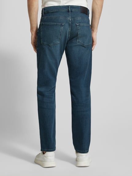 Mannenmodel draagt Straight Fit Jeans uit katoenmix model 'RE.MAINE BO CHANGE' van BOSS Orange in denim look, regular fit, label patch, klinknagels, riemlussen, knoopsluiting en verborgen ritssluiting, 5-pocket-design, achterkant volledige lichaamsweergave.