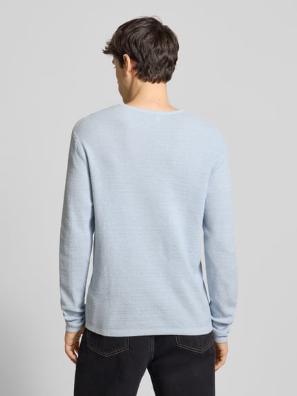 Männermodel trägt Strickpullover mit geripptem Rundhalsausschnitt Modell 'GEORGE' von Jack & Jones im Baumwoll-Mix, Ganzkörperansicht Rückansicht.