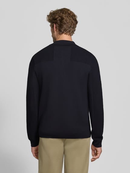 Mężczyzna nosi koszulkę polo Relaxed Fit z dodatkiem wełny model 'KN_Momentum-X PL' od BOSS Green, kolor granatowy, tekstura gładka, całkowity widok z tyłu.